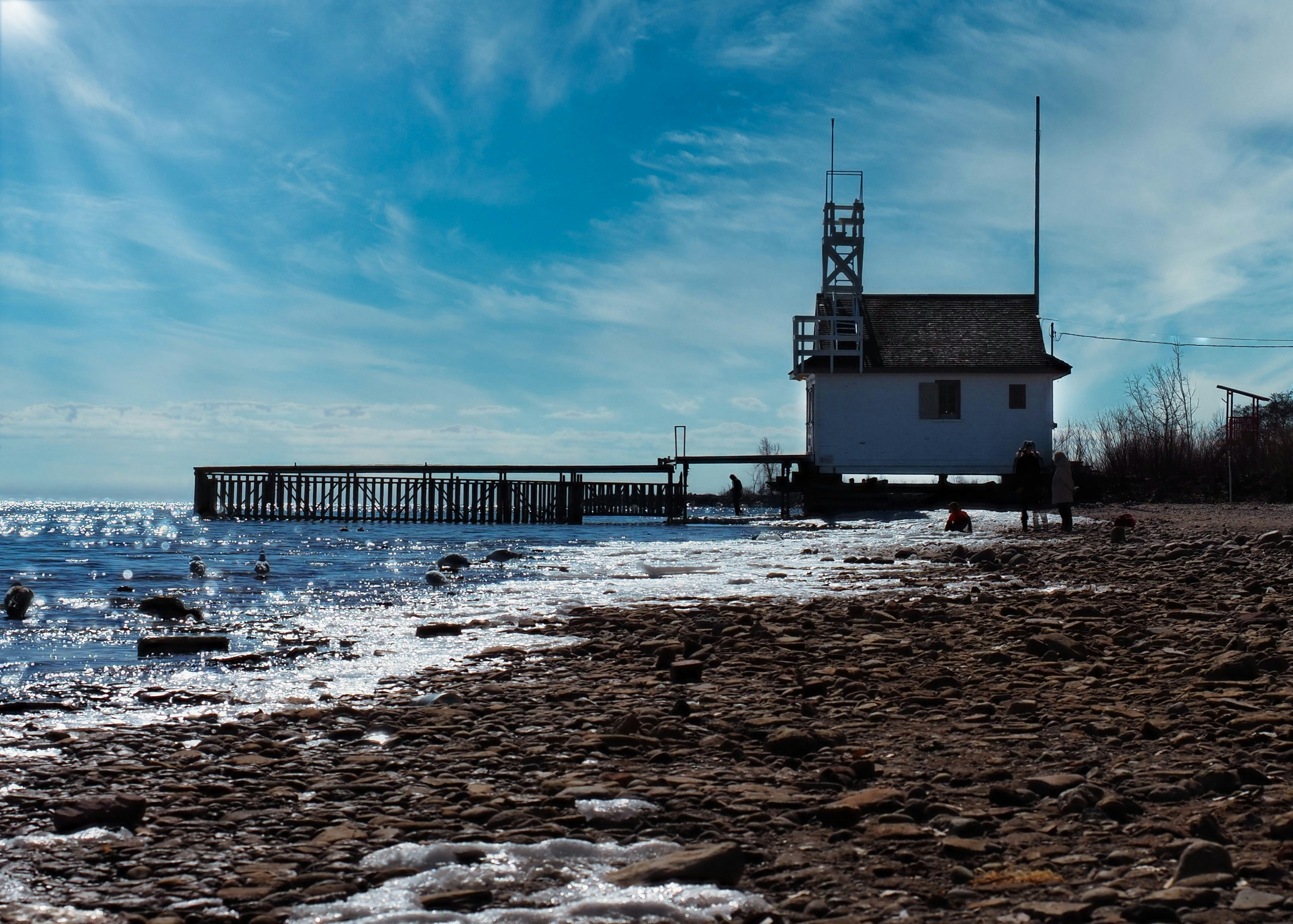 white and brown wooden house on beach during daytime