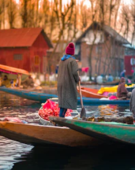 woman in red hijab sitting on green boat during daytime