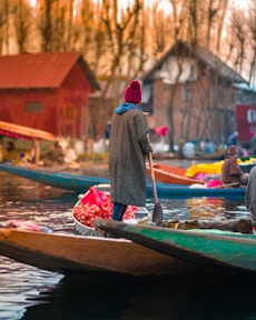 woman in red hijab sitting on green boat during daytime