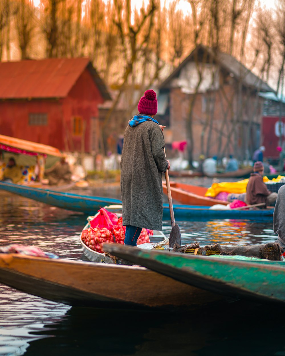 woman in red hijab sitting on green boat during daytime
