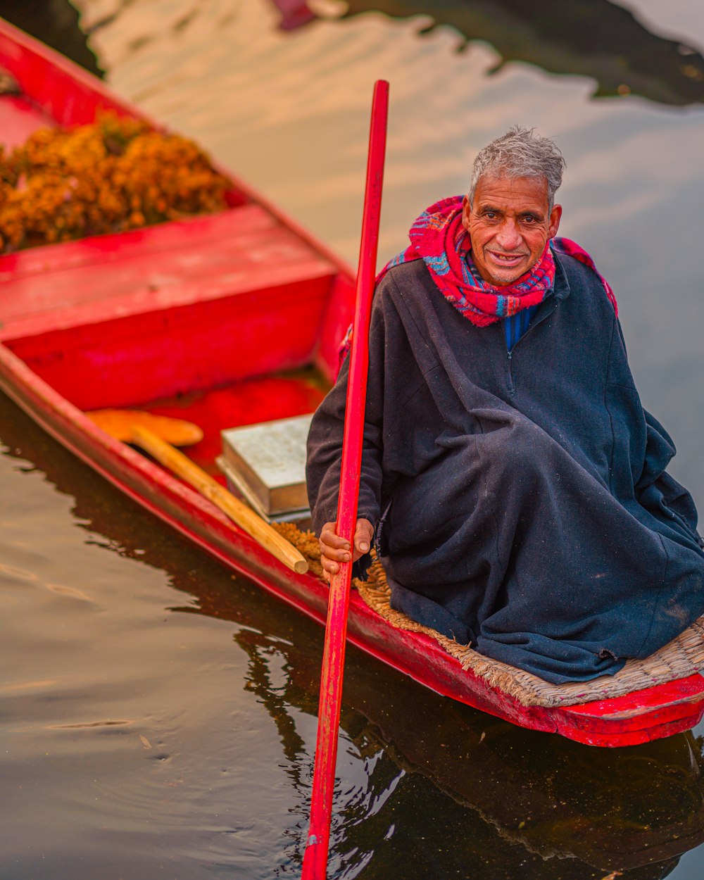 woman in blue jacket sitting on red boat