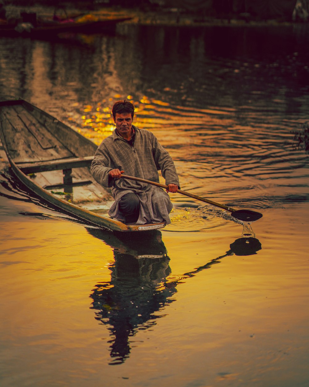 man in blue dress shirt riding on brown boat during daytime