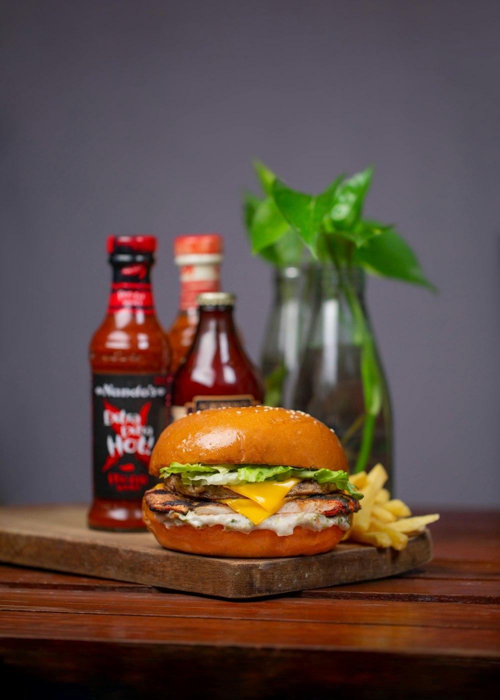 burger and fries on brown wooden chopping board