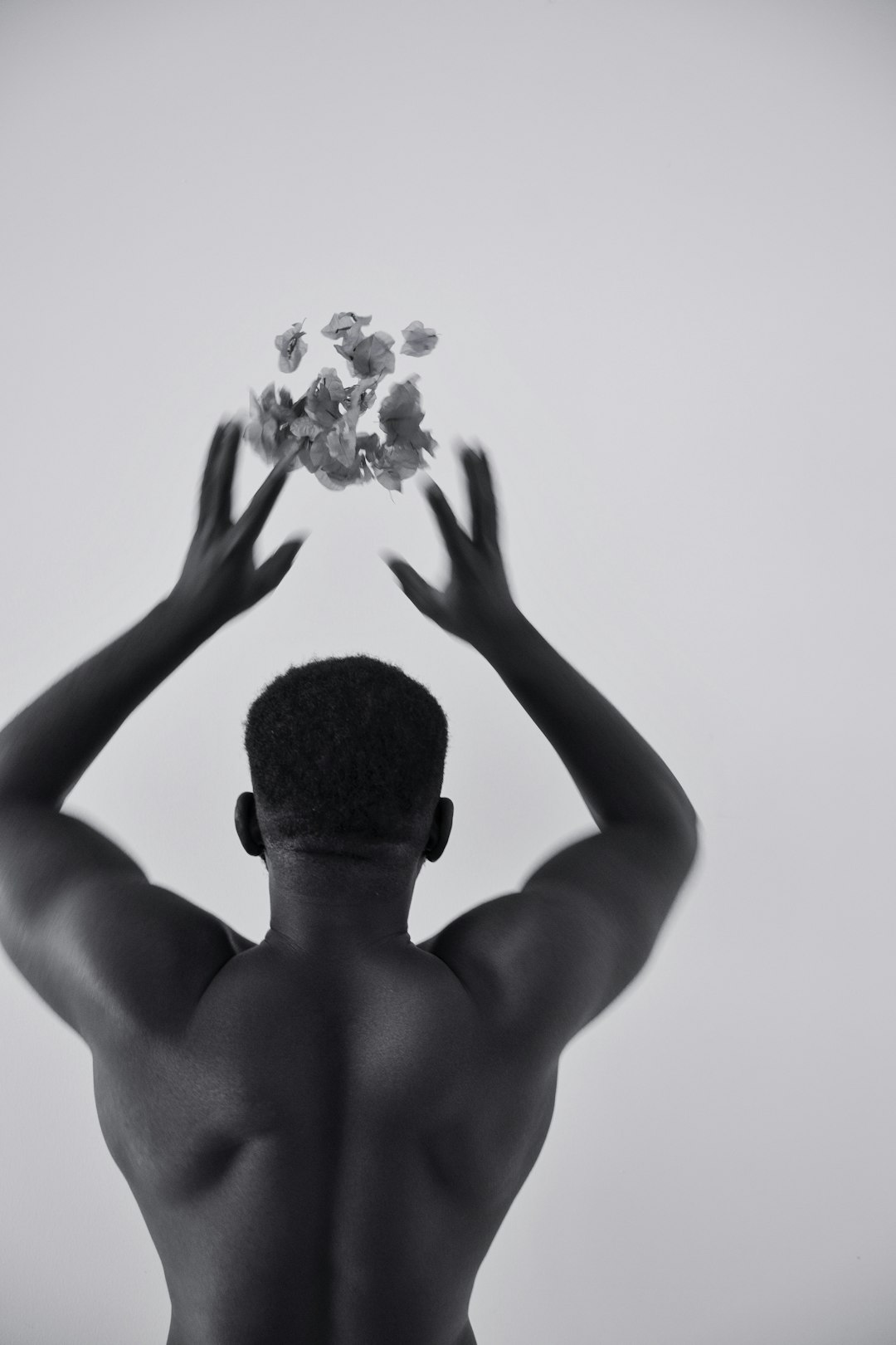 grayscale photo of man holding flower