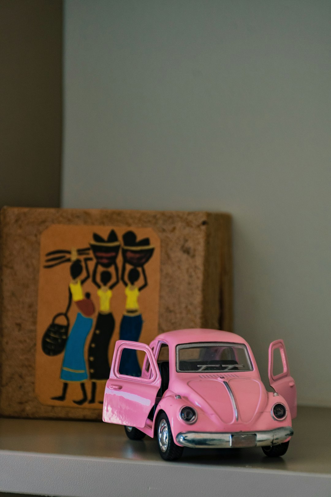 pink car toy beside brown cardboard box