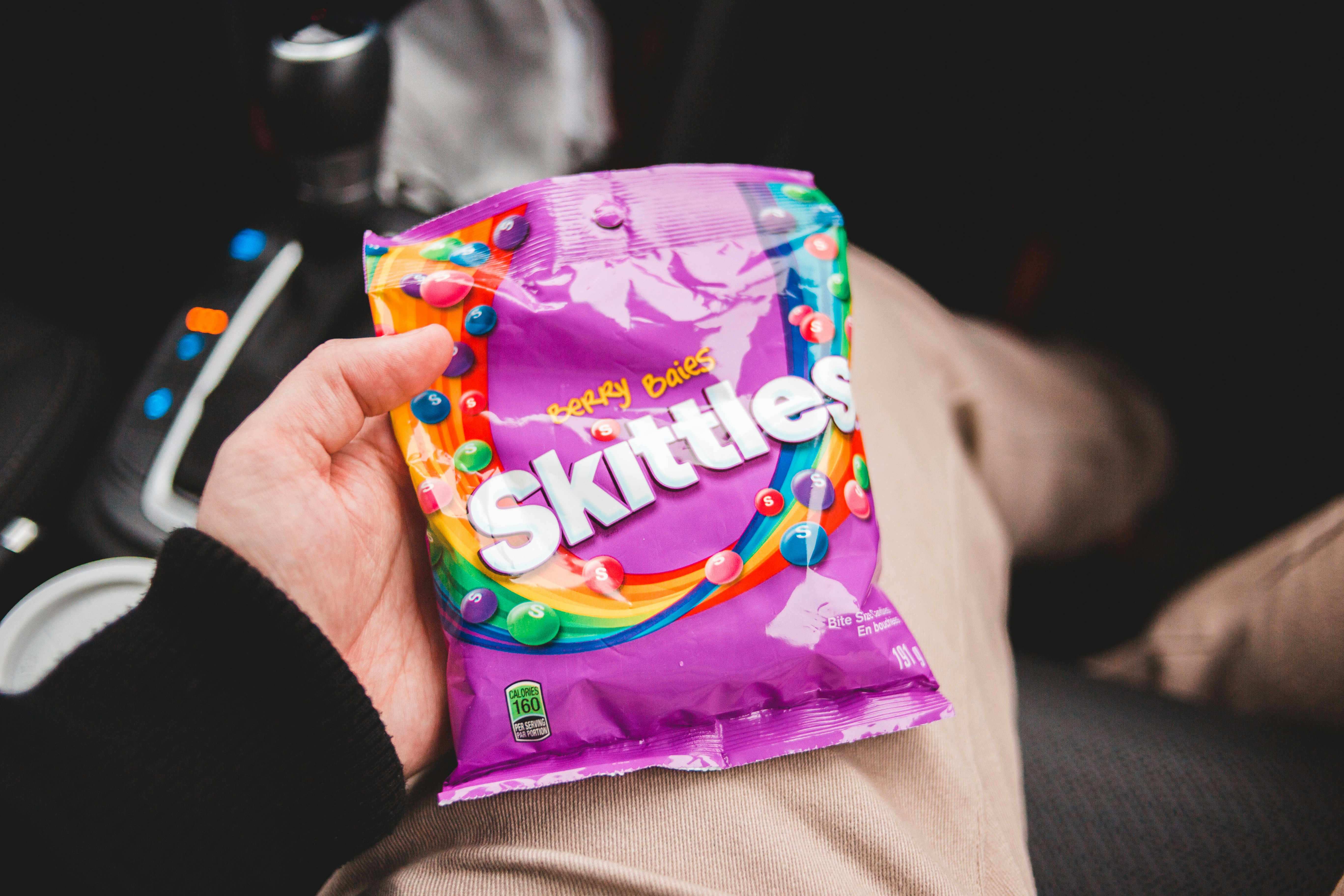 person holding purple and green plastic pack