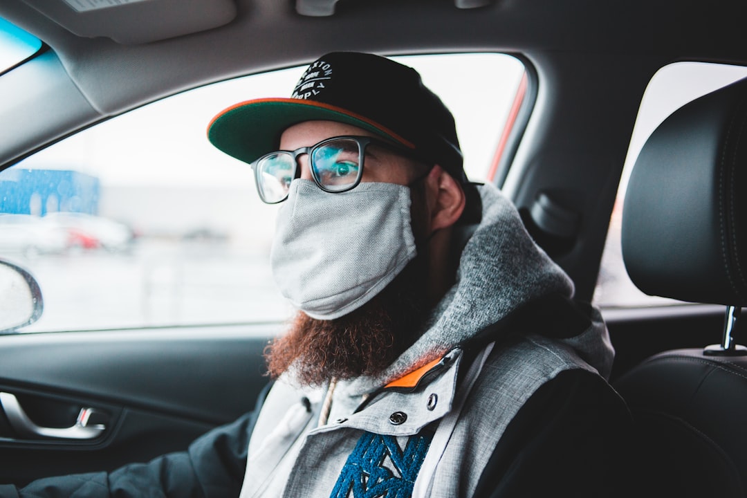 man in black jacket wearing black sunglasses and black cap