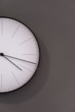 white analog wall clock at 11 00