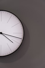 white analog wall clock at 11 00