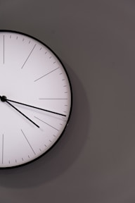 white analog wall clock at 11 00