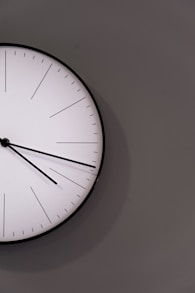 white analog wall clock at 11 00