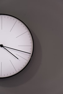 white analog wall clock at 11 00
