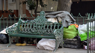 Modern street furniture crafted from recycled plastics, placed along a city sidewalk with greenery.
