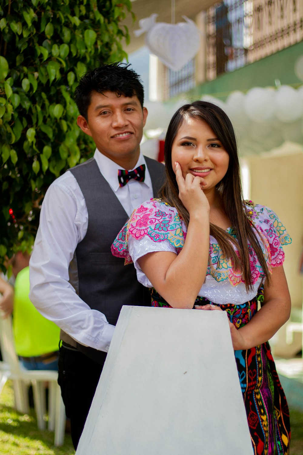 man in white dress shirt beside woman in pink floral dress