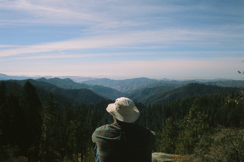 person in black jacket and gray knit cap standing on mountain during daytime