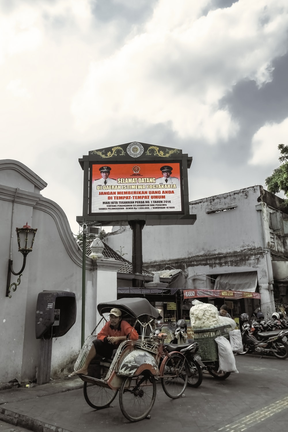 people sitting on red and black motorcycle near white concrete building during daytime