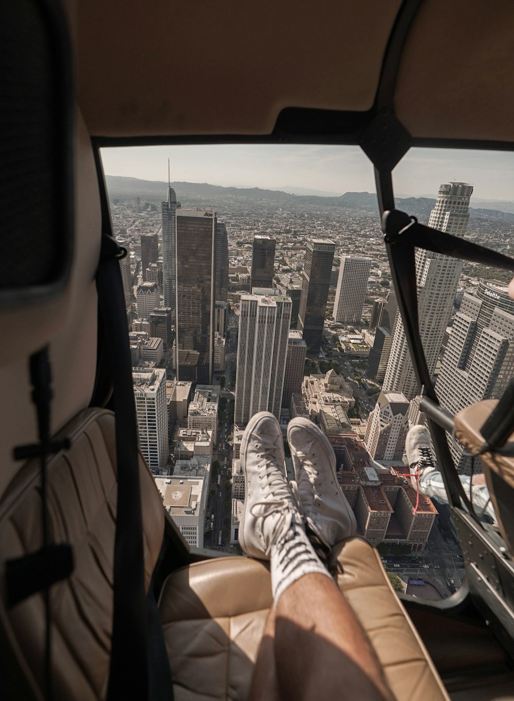 person in black pants and white sneakers sitting on car seat