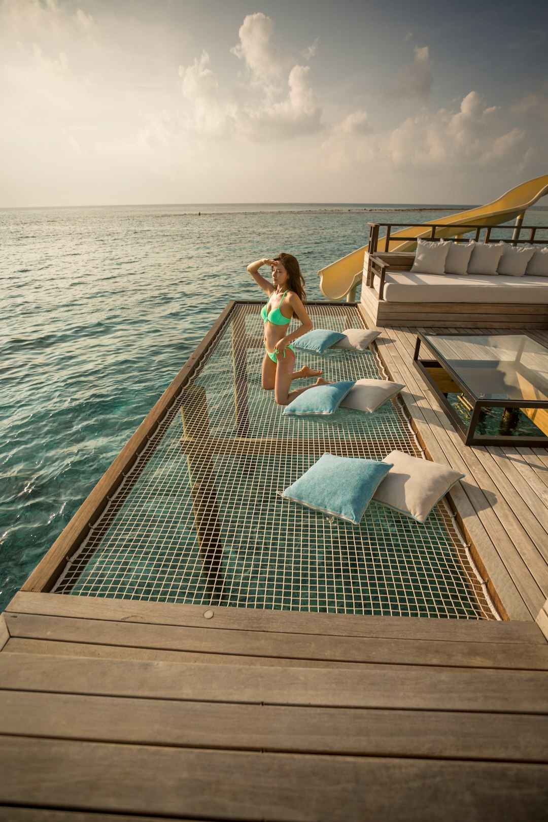 woman in white bikini sitting on brown wooden dock during daytime