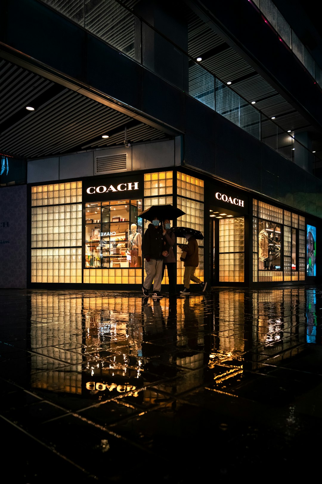 silhouette of 2 person standing in front of glass window