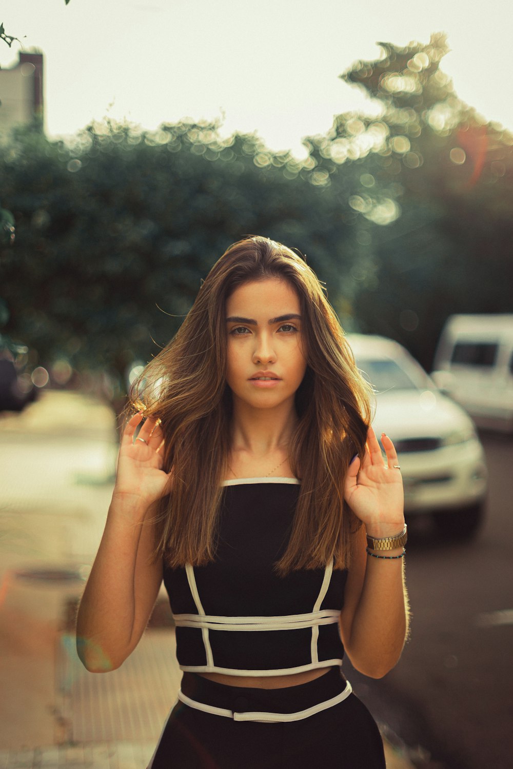 woman in black spaghetti strap top standing on road during daytime