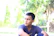 A thoughtful young man sitting outdoors, reflecting peacefully in nature.
