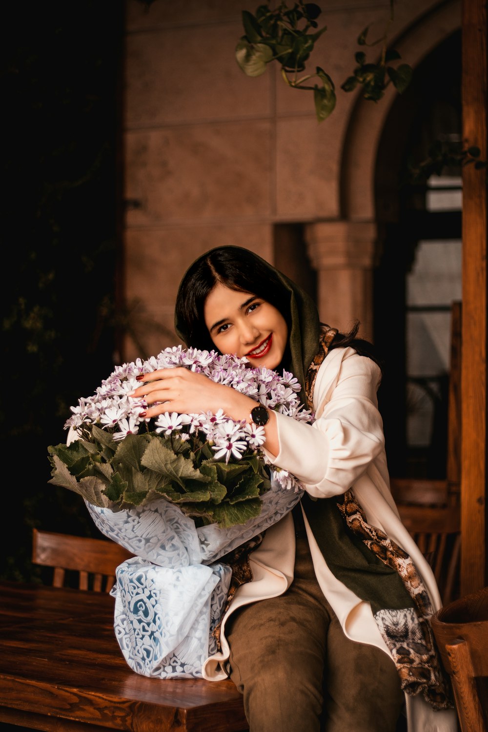 woman in white long sleeve dress holding bouquet of flowers