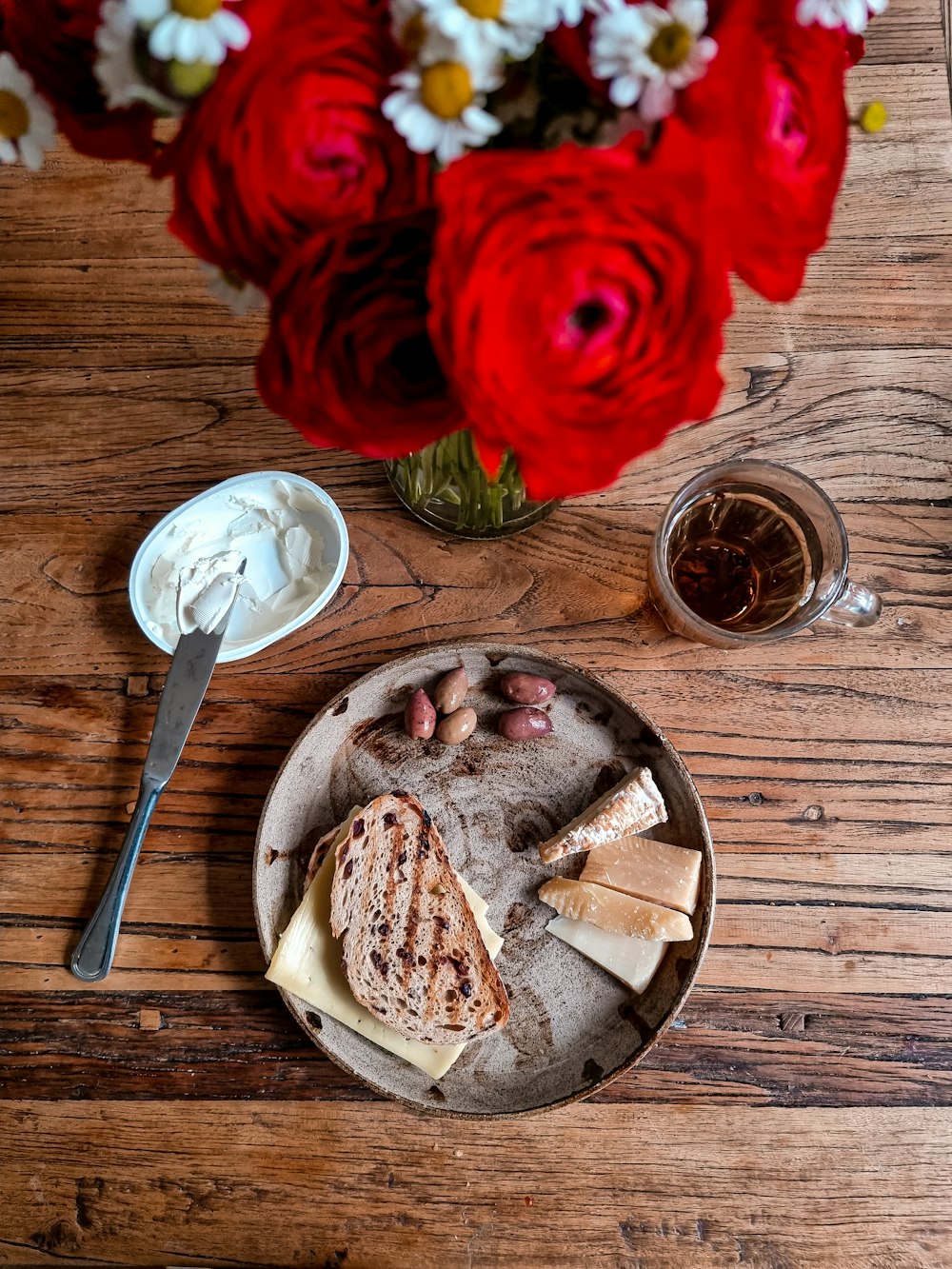 red rose beside sliced bread on brown wooden round plate