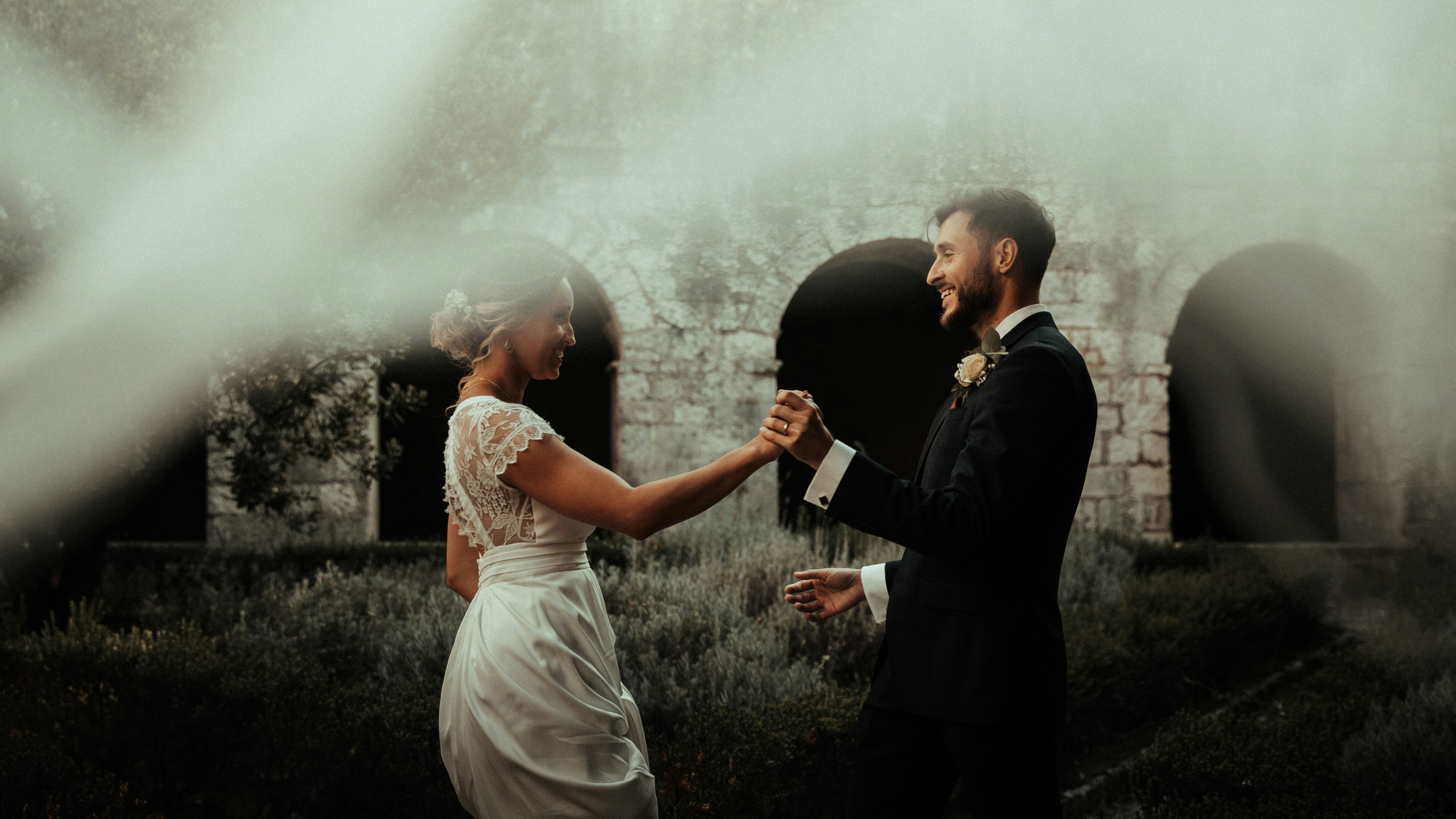 man in black suit jacket kissing woman in white dress