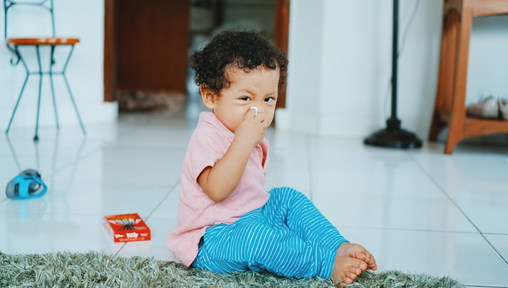 boy in blue and white striped long sleeve shirt lying on floor