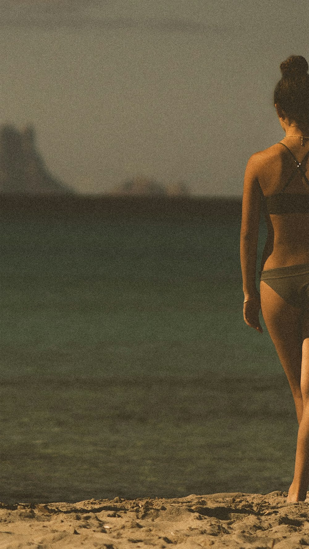 donna in bikini bianco in piedi sulla spiaggia