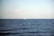 A ship sailing under clear skies symbolizing global maritime connections.