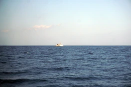 A ship sailing under clear skies symbolizing global maritime connections.