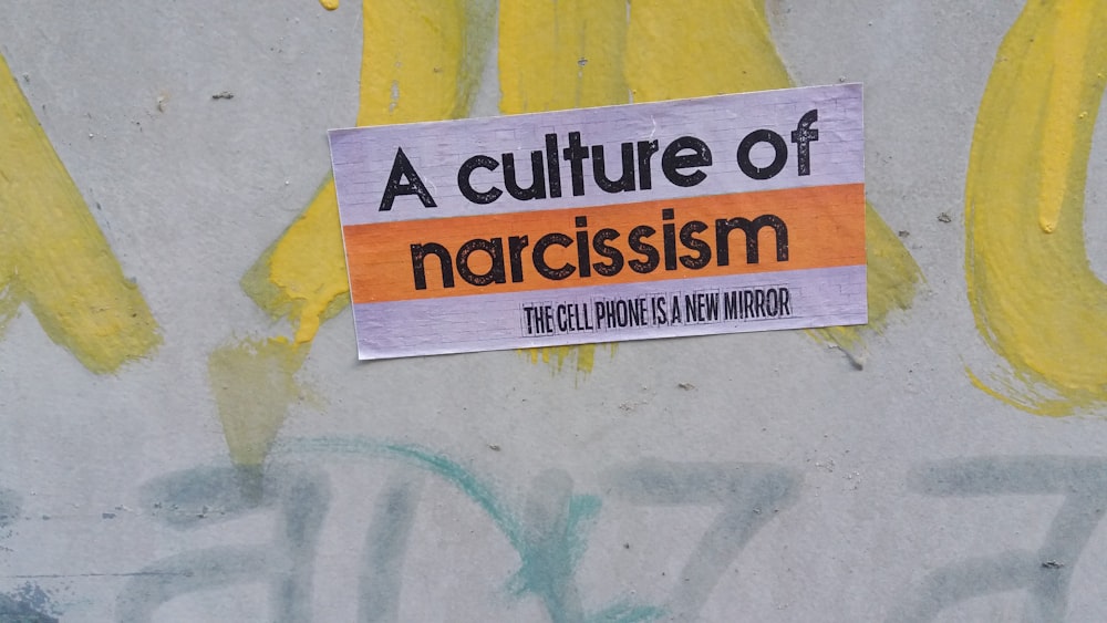 Un cartello sul lato di un muro che dice una cultura del narciso