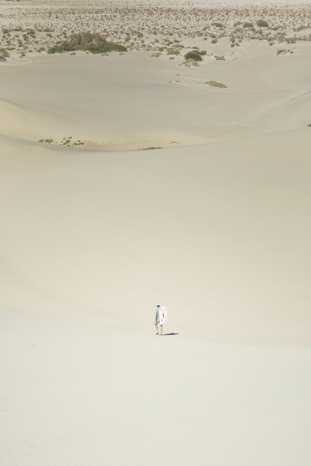 person in white shirt walking on sand