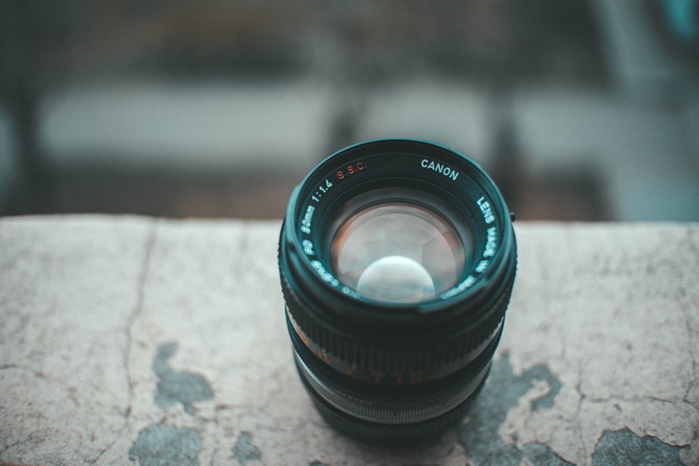 black camera lens on gray concrete surface