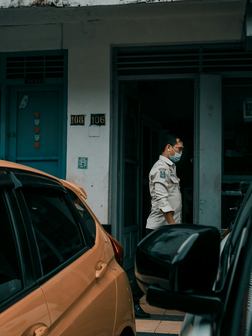 man in white dress shirt and black pants standing beside black car during daytime