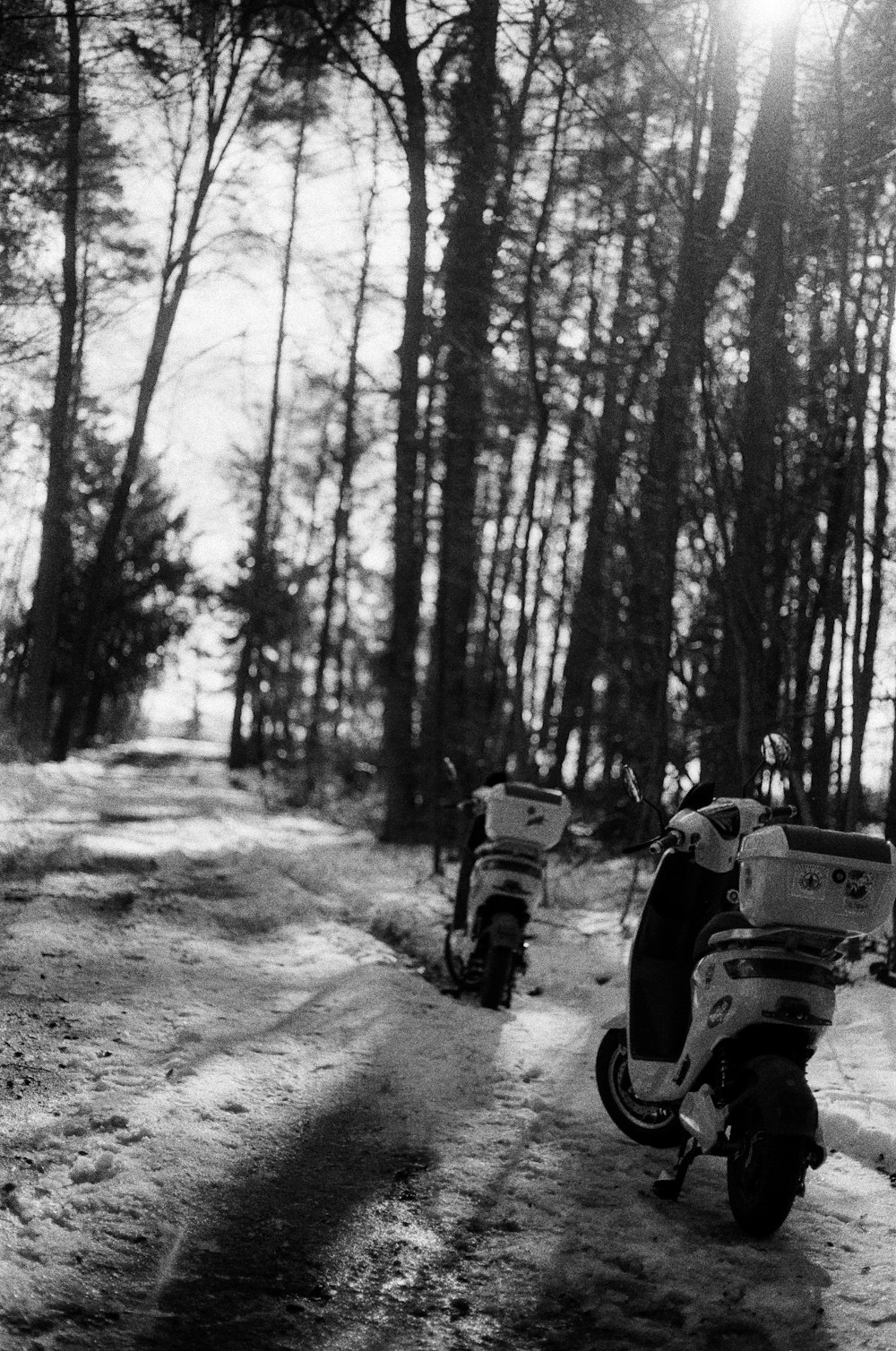 grayscale photo of man riding motorcycle on road