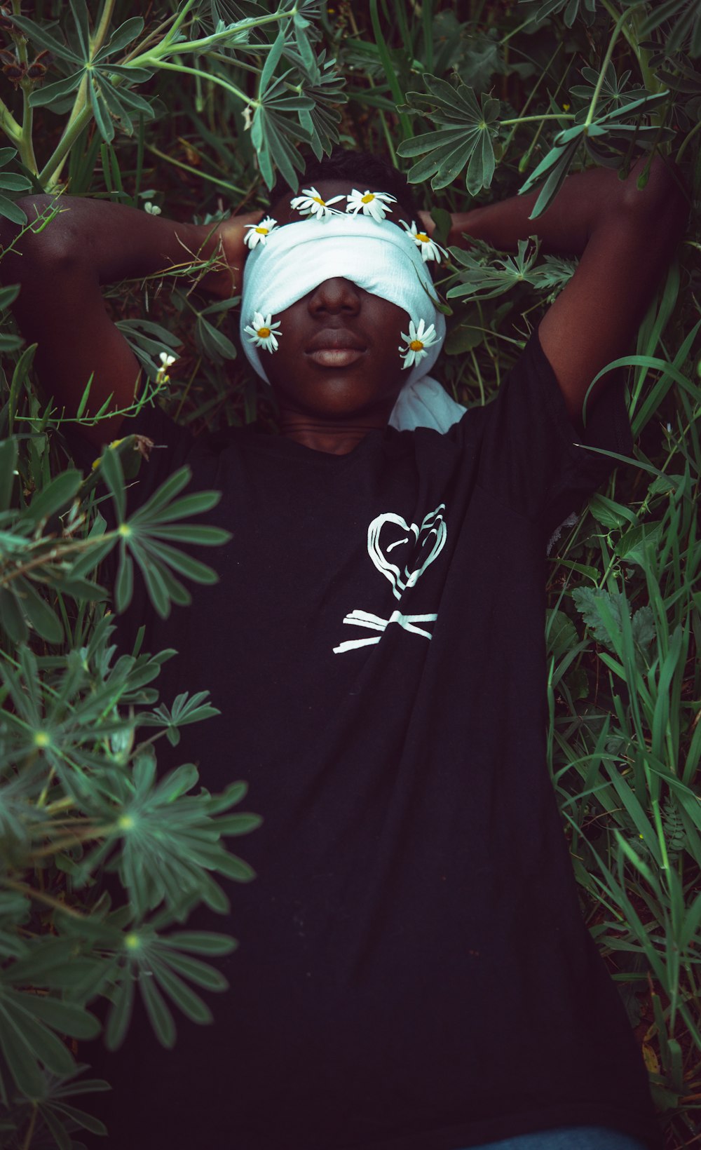 woman in blue crew neck t-shirt lying on green grass field during daytime