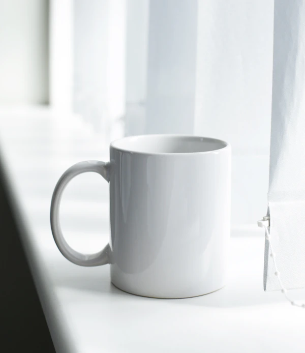 Handcrafted ceramic mugs on a wooden shelf