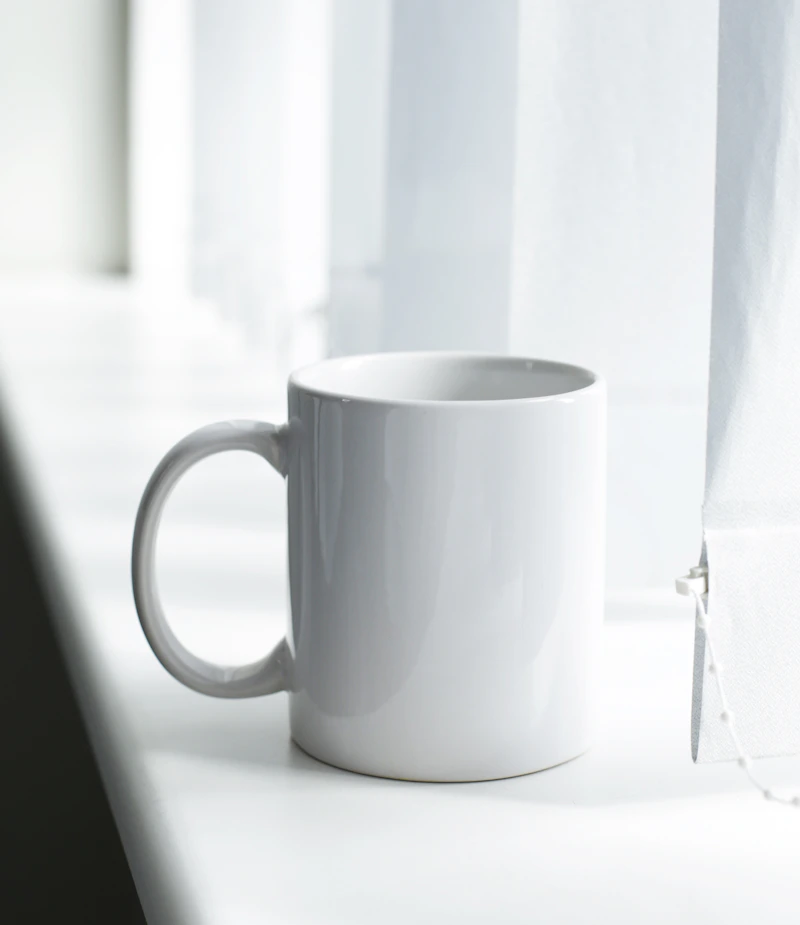 Ceramic mugs lined up on a rustic shelf