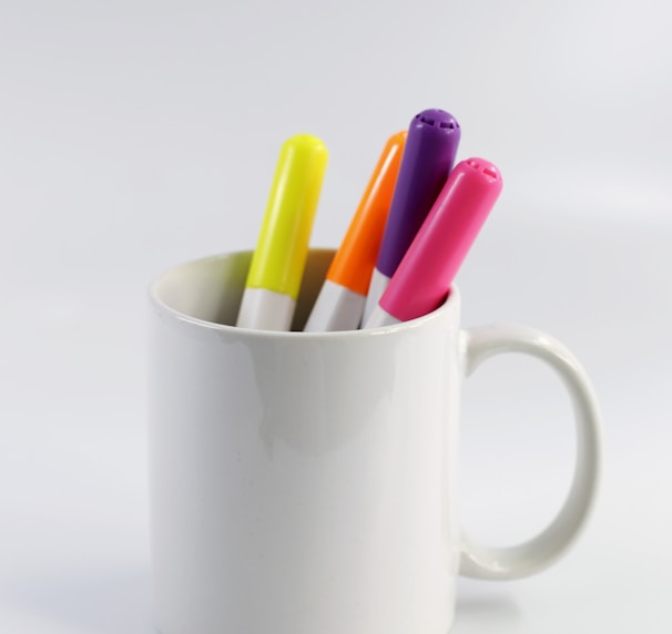 white ceramic mug with assorted color pencils