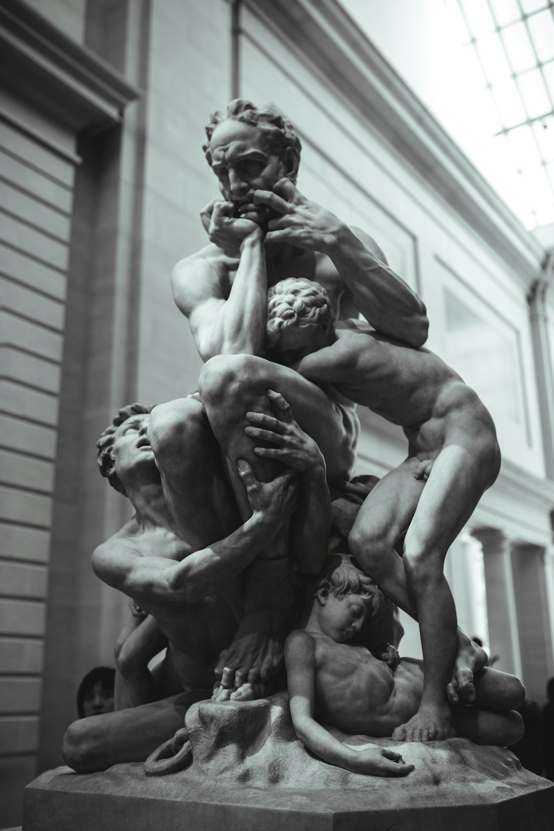 man and woman statue in grayscale photography