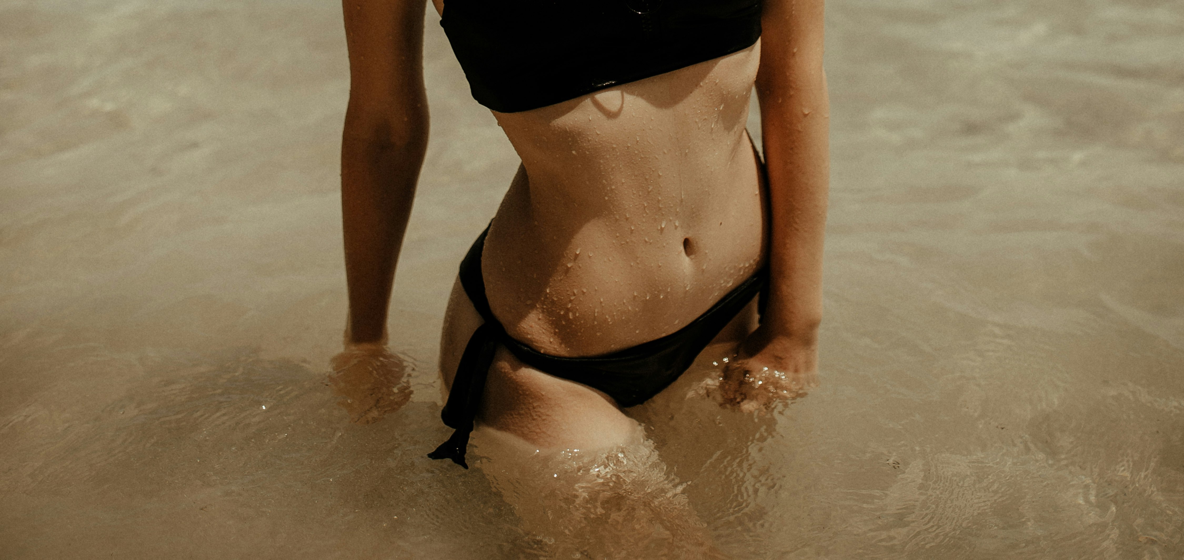 woman in black bikini bottom on water