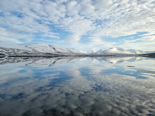 Clouds reflected in the still fjord — Akureyri, Iceland