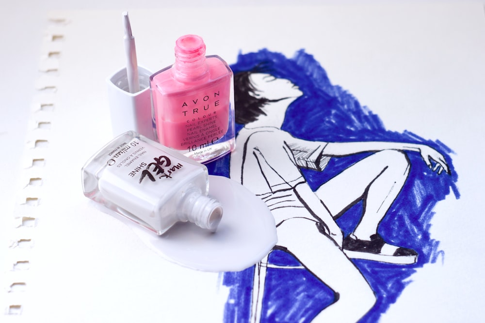 pink nail polish bottle on white and blue textile