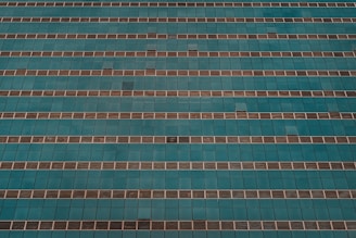 An aerial view of a large building undergoing painting services.