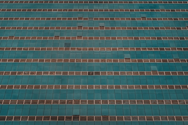 An aerial view of a large building undergoing painting services.