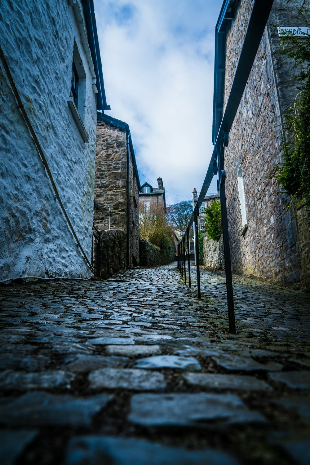 gray concrete pathway between brick buildings during daytime