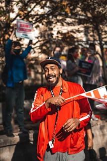 A smiling family holding Canadian flags at a border crossing.