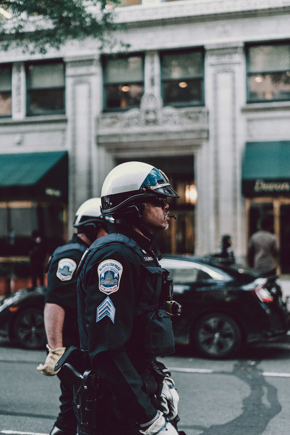 man in black helmet and black helmet standing near cars during daytime